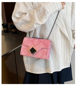 Detail of pink chain crossbody bag featuring quilted texture and geometric gold buckle