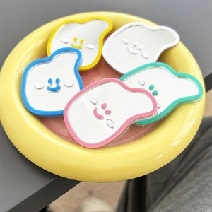 Macro shot of 5 colorful cloud-shaped acrylic phone mirrors on a yellow tray