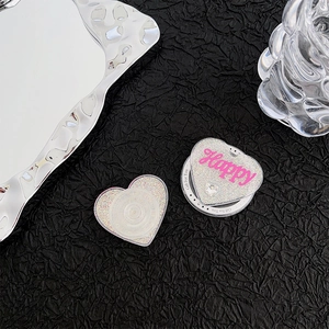 Detail of silver glitter heart phone grip with pink Happy lettering and rhinestone