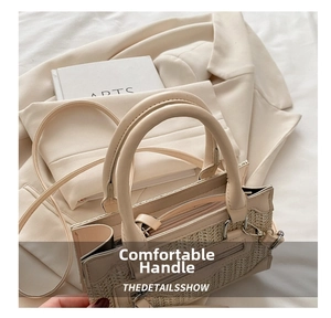 Close-up of woven straw handbag featuring leather trim and comfortable top handles