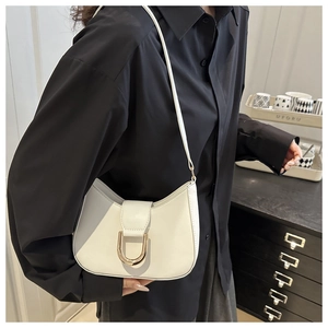 Detail of white dumpling bag with gold D-buckle closure and smooth matte leather texture