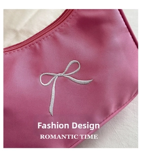 Macro shot of pink pleated fabric with detailed silver bow embroidery and zipper