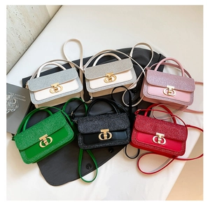 Detailed flat lay of six mini glitter handbags with circular metal twist locks and thin straps