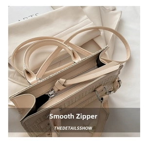 Detail of smooth metal zipper and woven texture on beige crossbody mini handbag