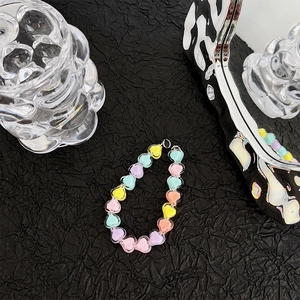 Detailed view of colorful heart-shaped resin beads on a textured black background