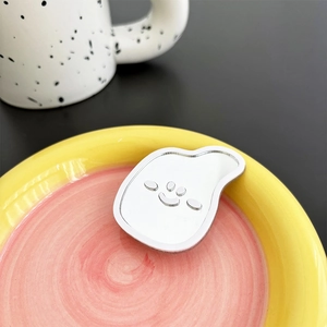 Close-up of a silver cloud-shaped mirror phone stand with a smiley face in a pink tray