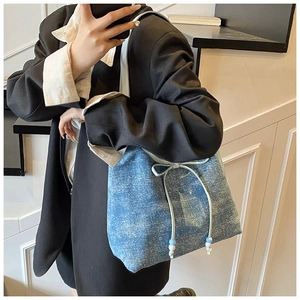 Detailed macro view of the blue denim tote bag featuring a bow tie and decorative beads
