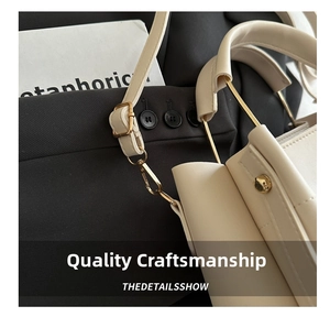 Detailed close-up of cream leather handbag with premium gold hardware and rivets