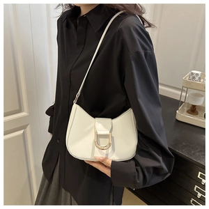 Close-up of white leather half-moon bag with elegant gold horseshoe metallic buckle