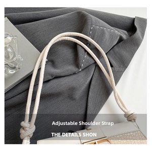 Detail of adjustable knotted strap and crocodile texture on cream baguette bag