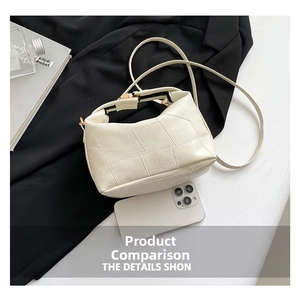 Size comparison of cream patchwork leather pillow bag next to a smartphone
