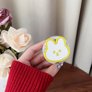Vue rapprochée d'un support de téléphone lapin mignon tenu en main sur fond floral
