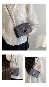 Detail of grey quilted chain bag with vintage texture and golden square metal clasp