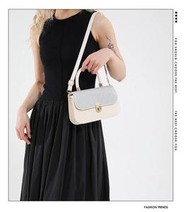 Detail view of beige crossbody bag featuring silver sequins and gold twist lock closure