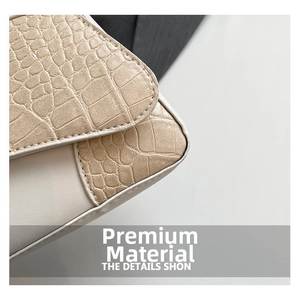 Close-up of cream crocodile pattern stitching and smooth leather texture on handbag