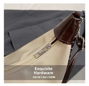 Detail view of silver zipper and hardware on cream and brown pebbled leather tote bag