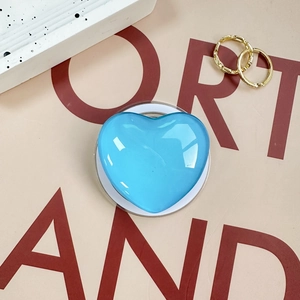 Sky blue heart-shaped phone griptok with a glossy resin finish and white adhesive base