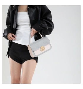 Detail shot of the glitter flap and gold circular metal buckle on the crossbody bag