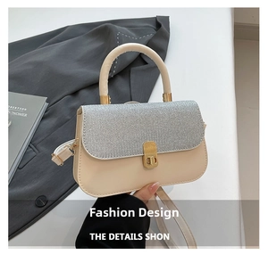 Detail of beige leather crossbody bag with silver glitter flap and gold twist lock
