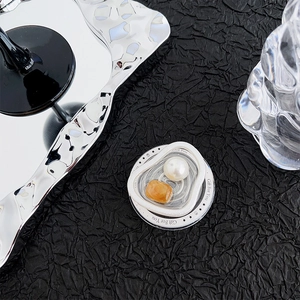 Detail of creative phone grip with pearl and amber gem design on textured background