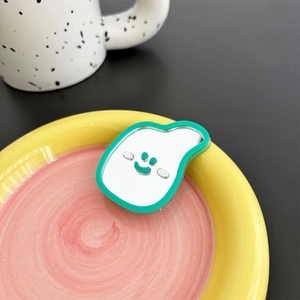 Detail of banana shape phone grip with green edges and a smiley face mirror finish