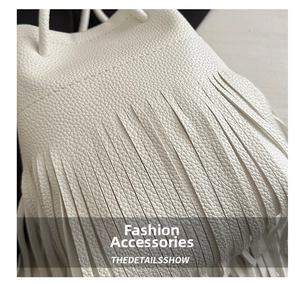 Close-up of white lychee pattern leather bucket bag with dense long fringe details