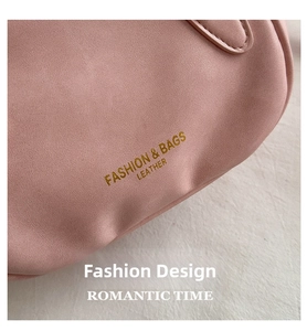 Detailed macro view of pink litchi grain leather bag with gold embossed fashion lettering
