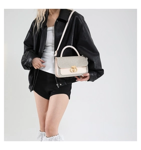 Detailed view of beige sequin crossbody bag with gold rotating lock and top handle