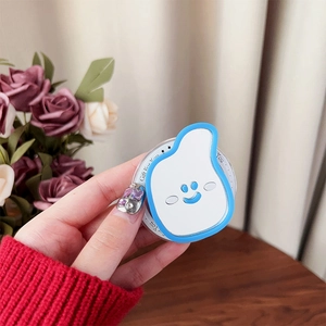 Close-up of cute white smiley phone grip with transparent base on a cozy floral background