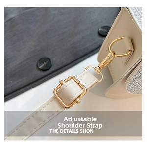 Detail of adjustable PU leather shoulder strap with gold-tone buckle on cream crossbody bag
