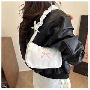 Detail of white hobo bag with pink bow embroidery and pleated shoulder strap handle