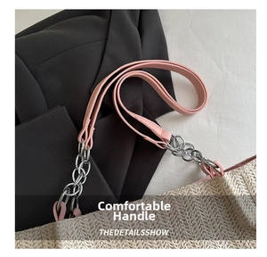 Detail of woven tote bag featuring pink leather strap and silver metal chain accents