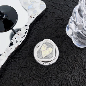 Detailed shot of holographic heart phone grip with Gift For You print on black texture