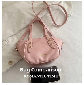 Pink rivet handbag size comparison with smartphone on white fabric background