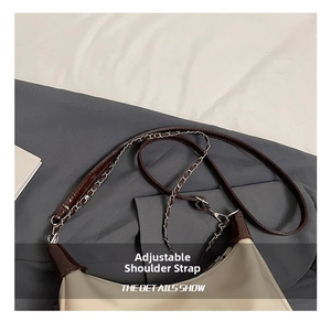 Detail view of adjustable shoulder strap featuring leather and silver metal chain link