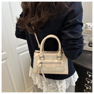 Detail of beige woven texture and leather tassels on a stylish crossbody handbag
