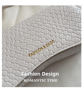 Close-up of white woven texture bag with golden Fashion & Bags lettering detail