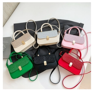Flat lay of small crossbody bags in six vibrant colors with sparkly lids and gold knobs
