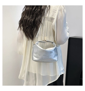 Close-up of metallic silver PU leather shoulder bag with textured square patchwork design