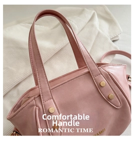 Detail of pink faux leather bucket bag with gold rivets and & BAGS gold lettering