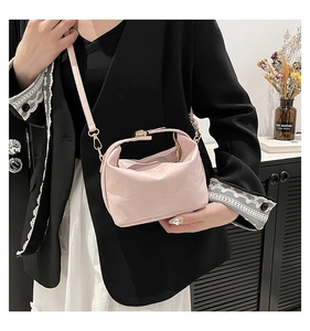 Detail of light pink woven leather texture with gold metal buckle on bucket bag