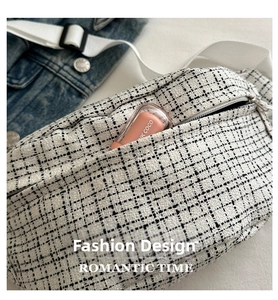 Close-up of black and white tweed saddle bag showing texture and interior capacity
