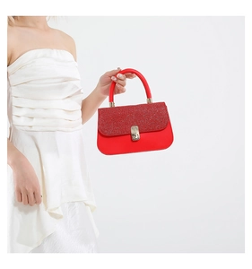 Detail of red glitter flap and golden turn-lock closure on vintage shoulder bag