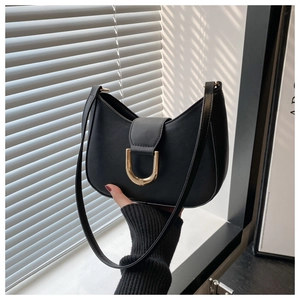 Detailed macro view of the gold U-shaped buckle on black matte leather hobo bag