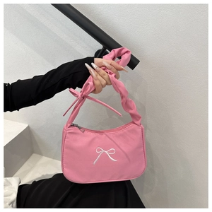 Detailed shot of pink tote with white bow embroidery and pleated handle design