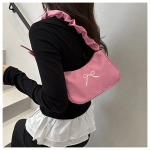 Pink shoulder bag detail showing stylish white bow embroidery and pleated scrunchie strap
