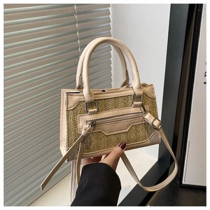 Detail of the woven texture and leather tassel on the vintage straw crossbody bag