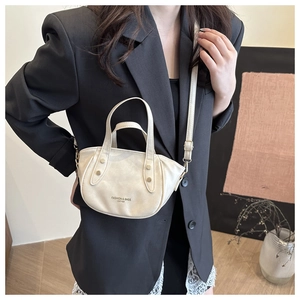 Detail of off-white leather mini bucket bag with vintage studs and crossbody strap
