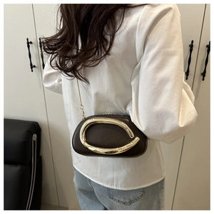 Dettaglio mini borsa in pelle caffè con anello dorato e tracolla a catena sottile
