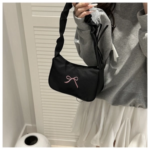 Detail of pink bow embroidery on black canvas shoulder bag with scrunchie strap design
